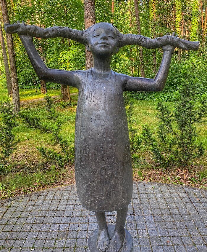 Statue of a girl holding out her braids to the side