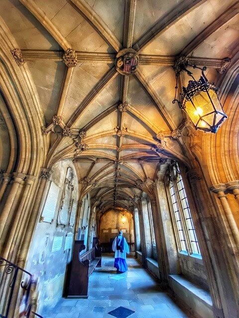 Priest walking down the corridor of Christ Church in Oxford