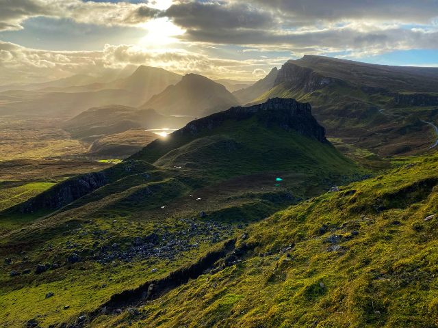 View from the Quiraing trail overlooking Loch Leum an Luirginn. An artist is standing on the ridge painting the view.